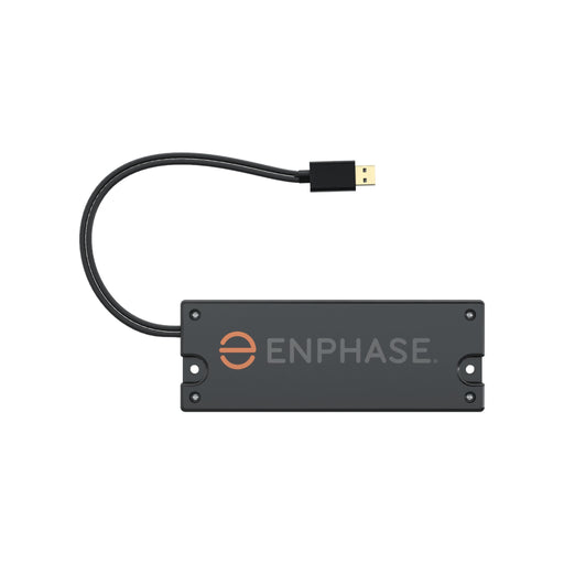 The device is a rectangular black Enphase COMMS-KIT-01 Communications Kit from Enphase Energy, featuring the word ENPHASE and an orange logo on the front. It includes a short cable extending from one side that ends in a USB connector, similar in appearance to an IQ Gateway.